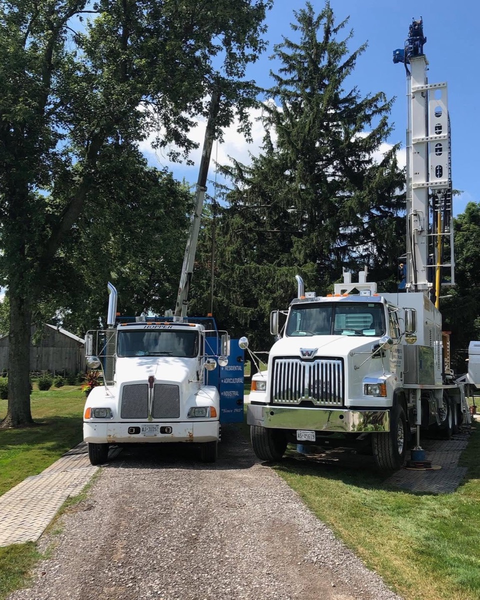 A Hopper drill rig and support truck set up on a job site in Southern Ontario