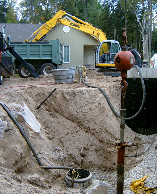 Flowing drilled well inside a wooden dug well
